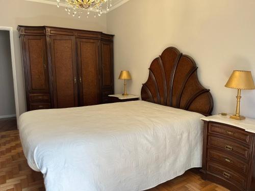 - une chambre avec un grand lit et des placards en bois dans l'établissement Olympic Apartment, à Braga