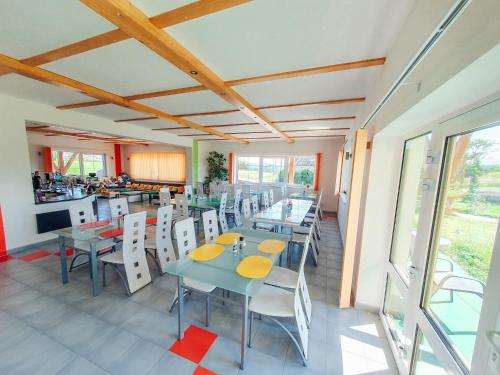 a restaurant with tables and chairs and a kitchen at Penzion Patriot in Výprachtice