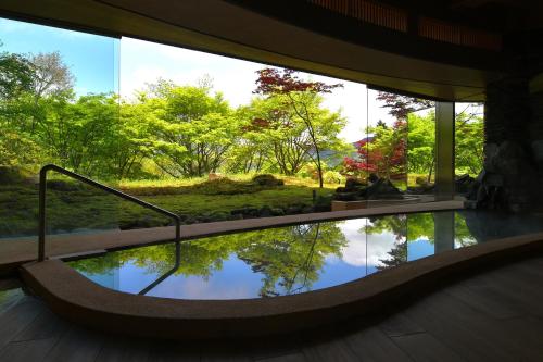 a reflection of trees in a pool of water in a building at Hakone Gora Byakudan in Hakone