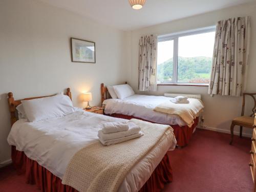 two beds in a room with a window at Fellcroft in Ambleside
