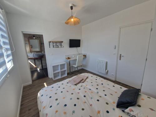 a bedroom with a bed and a desk at Le Nid Cabailla in Coimères