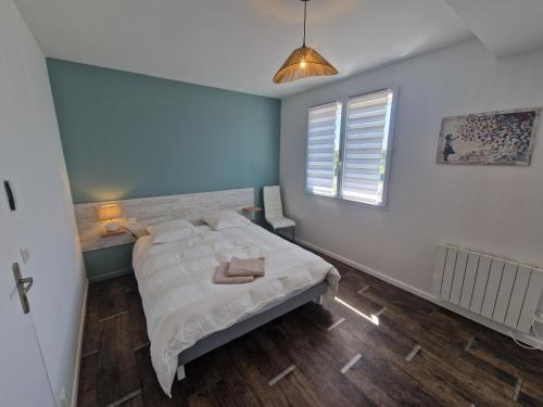 a bedroom with a large bed in a room with blue walls at Le Nid Cabailla in Coimères