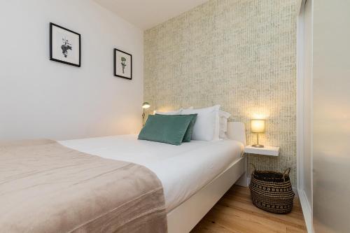 a bedroom with a large white bed and two lamps at Design and bright studios near Pastéis de Belém in Lisbon