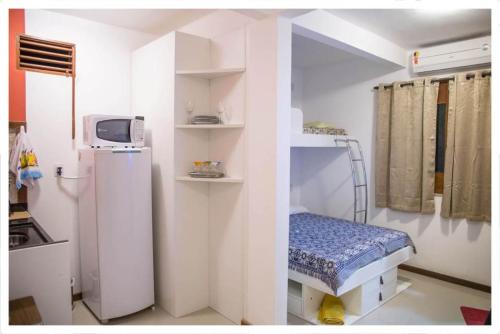 a hospital room with a bed and a refrigerator at Promocional 3 Pessoas Vila Praia do Forte in Mata de Sao Joao