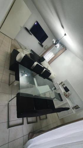 une pièce avec une table en verre et des chaises noires dans l'établissement Bienvenue à Carcassonne, à Carcassonne