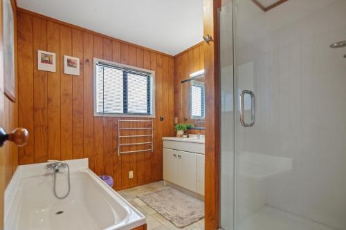 La salle de bains est pourvue d'une baignoire, d'une douche et d'un lavabo. dans l'établissement Mayor Magic - Onemana Holiday Home, à Opoutere