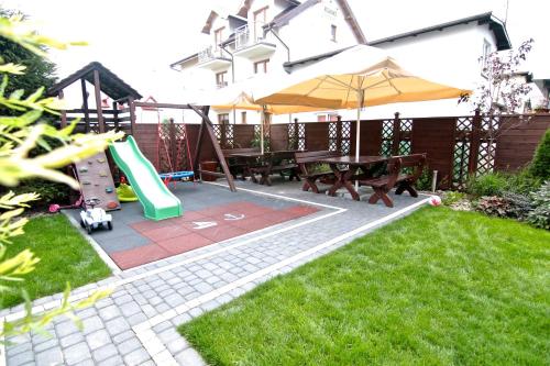 a playground with a slide and a table and an umbrella at Willa Sara Karwia in Karwia