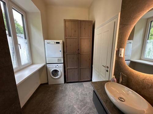ein Badezimmer mit einer Waschmaschine und einem Waschbecken in der Unterkunft Book-A-Room Salzburg Apartment 33-A in Salzburg