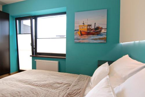 a bedroom with a bed and a painting of a boat at Willa Sara Karwia in Karwia