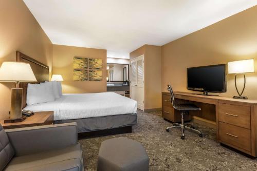 a hotel room with a bed and a desk with a television at Best Western Plus Inn Scotts Valley in Scotts Valley