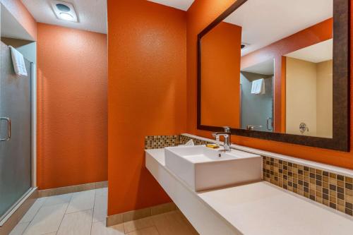 an orange bathroom with a sink and a mirror at Best Western Plus Inn Scotts Valley in Scotts Valley