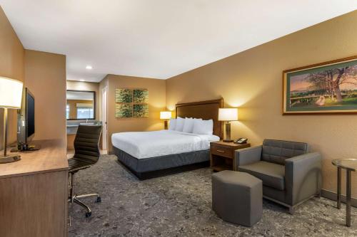 Best Western Plus Inn Scotts Valley في سكوتس فالي: غرفة الفندق بسرير ومكتب وكرسي