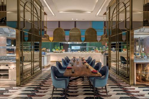 une salle à manger avec une grande table et des chaises dans l'établissement Radisson Blu Hotel & Spa, Nashik, à Nashik