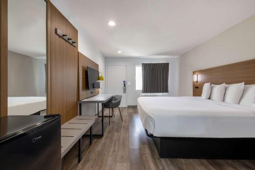 a hotel room with a large bed and a desk at Motel 6-Santa Ana, CA in Santa Ana