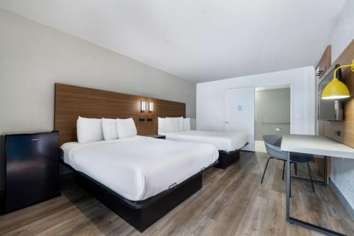 a hotel room with two beds and a desk at Motel 6-Santa Ana, CA in Santa Ana