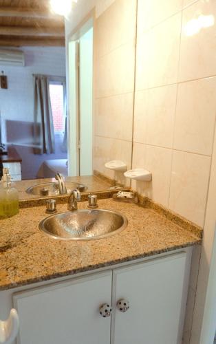 a bathroom counter with two sinks and a mirror at Cabañas "El Valle" in San Rafael