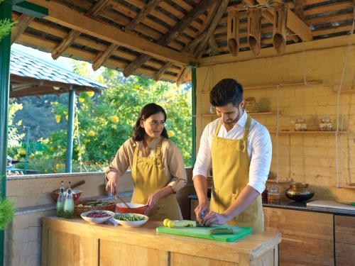 a man and woman in a kitchen preparing food at Rakkh Resort, a member of Radisson Individuals Retreats in Pālampur