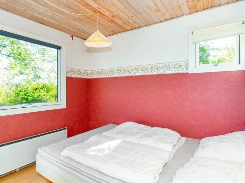 FlovtrupにあるTwo-Bedroom Holiday home in Roslev 2の赤い壁のベッドルーム1室、ベッド2台が備わります。