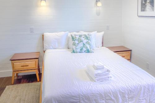 a bedroom with a white bed with towels on it at Tupelo Suite in Apalachicola