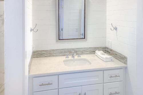 a white bathroom with a sink and a mirror at Tupelo Suite in Apalachicola