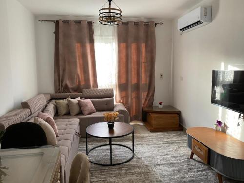a living room with a couch and a table at شقة فندقية فاخرة لعشاق الهدوء والسكن الراقي في مدينتي in Madinaty