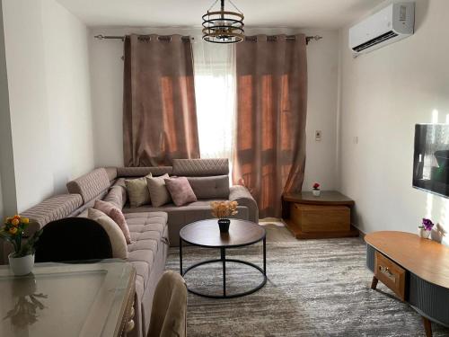 a living room with a couch and a table at شقة فندقية فاخرة لعشاق الهدوء والسكن الراقي في مدينتي in Madinaty