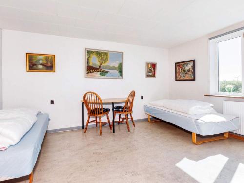 a bedroom with two beds and a table and chairs at 12 person holiday home in Roslev-By Traum in Roslev