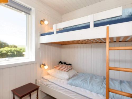 - une chambre avec des lits superposés, une table et une fenêtre dans l'établissement Holiday home Nykøbing M VII, à Alsted