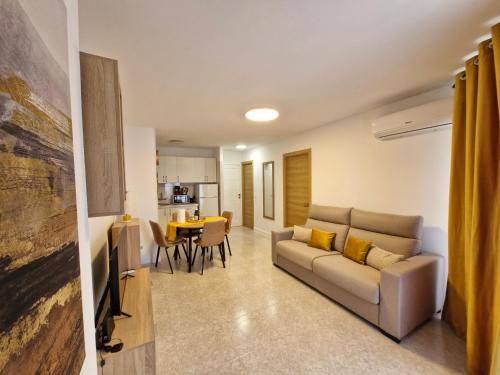 ein Wohnzimmer mit Sofa und Tisch in der Unterkunft Beach View Las Americas in Playa de las Americas