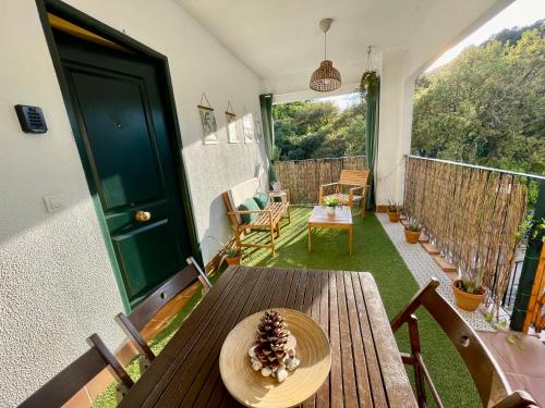 een veranda met een houten tafel met een dennenappel erop bij Casa Rural Una Ventana a la Sierra in Aracena
