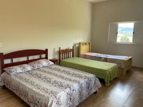 a bedroom with two beds and a window at Sítio Vale Encantado in Soledade de Minas