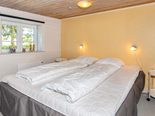 a large white bed in a room with a window at 5 person holiday home in Karby-By Traum in Karby