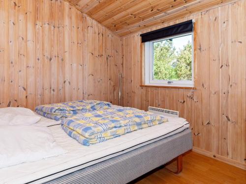 a bed in a wooden room with a window at Holiday home Thisted XXI in Sønder Vorupør