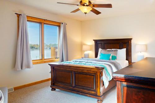 Lake Minocqua Lakeview في مينوكوا: غرفة نوم مع سرير مع مروحة سقف ونافذة