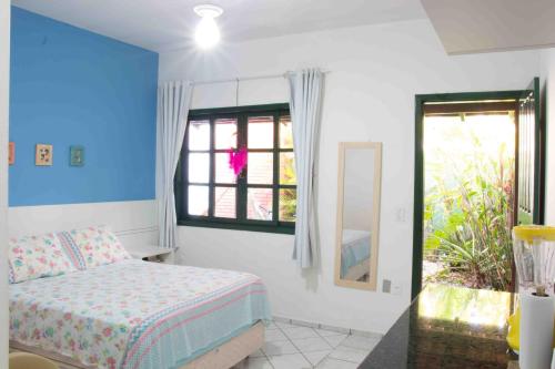 a bedroom with a bed and a window at Canto das Ondas Apart Studios in São Francisco do Sul