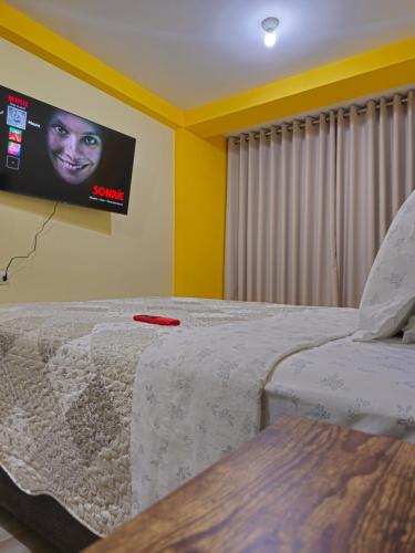 a bedroom with a bed with a tv on the wall at Departamento en Huanchaco Beach in Huanchaco