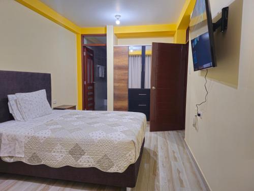 a bedroom with a bed and a flat screen tv at Departamento en Huanchaco Beach in Huanchaco