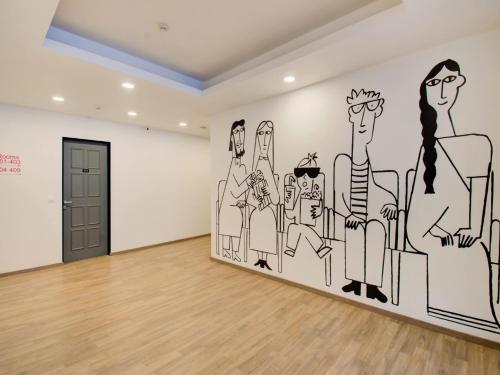 ein Zimmer mit einem Wandbild einer Gruppe von Personen in der Unterkunft Townhouse XOTEL in Bangalore