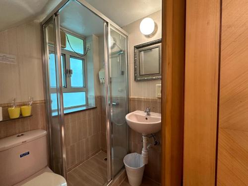 a bathroom with a shower and a sink and a toilet at Bali Holiday Resort in Hong Kong