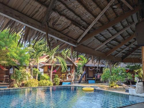 a swimming pool in a resort with an umbrella at Munchies Bungalows in Ban Tai