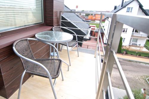 balkon z 3 krzesłami, stołem i oknem w obiekcie Willa Sara Karwia w Karwii