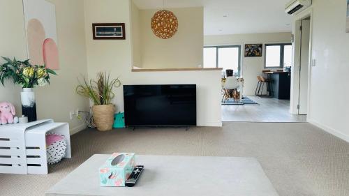 a living room with a flat screen tv and a living room at Sea views from sunny house in Wellington