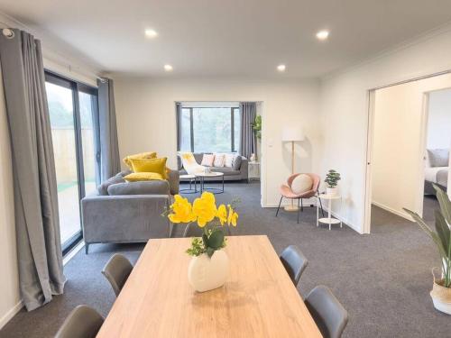 ein Wohnzimmer mit Tisch und Couch in der Unterkunft Rotorua Sunshine Brand New 4 Bedroom house in Rotorua