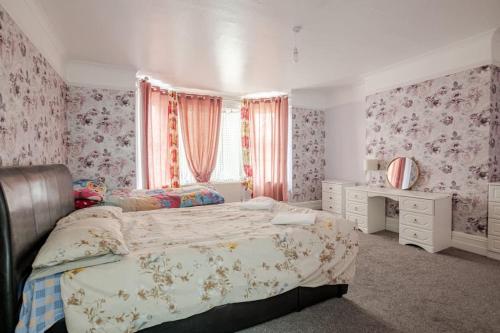 a bedroom with a large bed and a window at North Denes Villa in Great Yarmouth