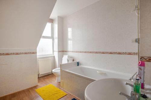 a bathroom with a tub and a sink and a toilet at North Denes Villa in Great Yarmouth