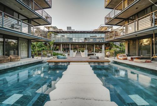 a house with a swimming pool in front of a building at Unique 1BR Swim up Cenote, and Gym in Tulum