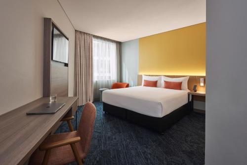 a hotel room with a bed and a desk at Rydges Sydney Airport Hotel in Sydney