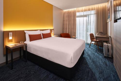 a hotel room with a large bed and a desk at Rydges Sydney Airport Hotel in Sydney