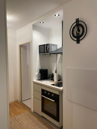 une petite cuisine avec une cuisinière et un micro-ondes dans l'établissement Chevilly Cosy, à Chevilly-Larue