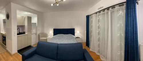 - un salon avec un canapé bleu et un lit dans l'établissement Chevilly Cosy, à Chevilly-Larue